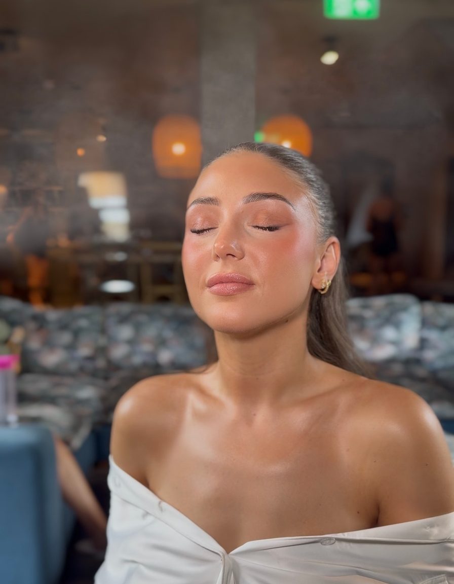 A bride with eyes closed showing soft glowing eye makeup, getting ready on her wedding morning