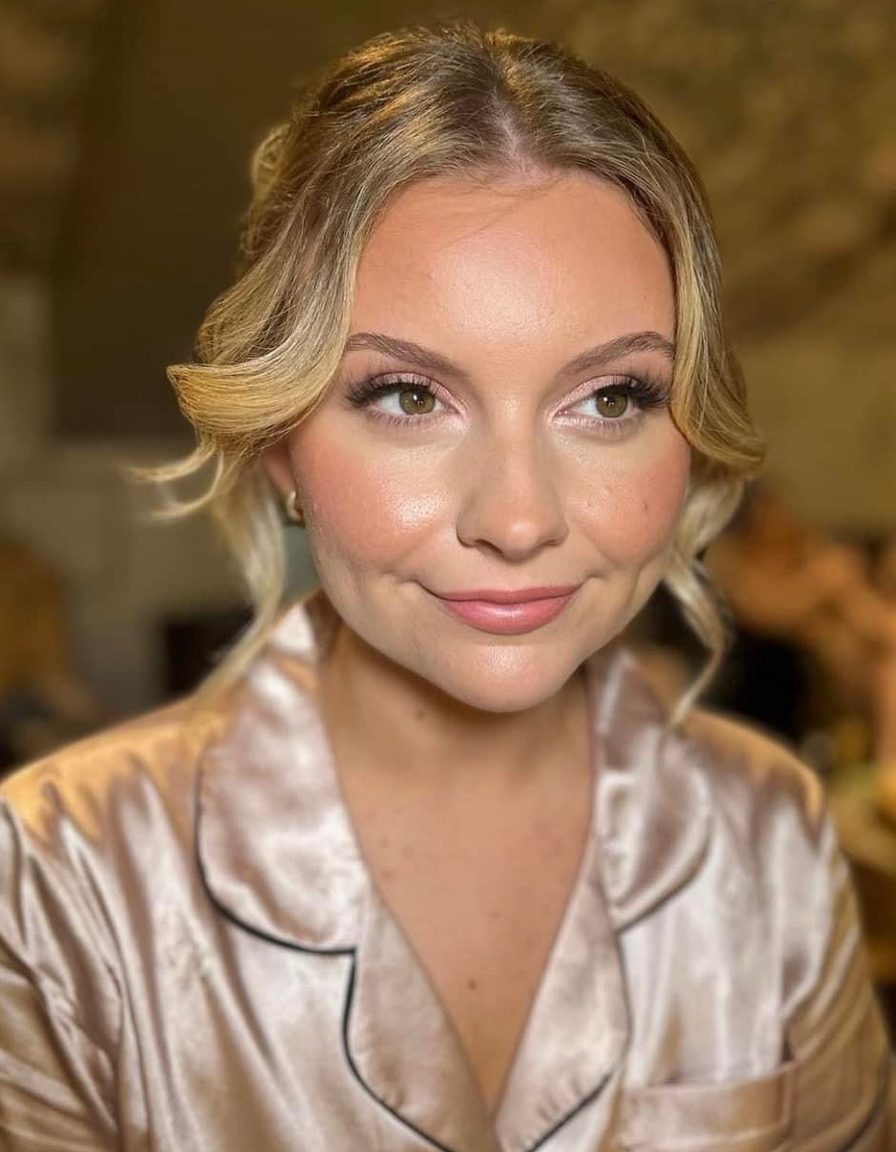 A bridesmaid in satin pyjamas with soft glam makeup